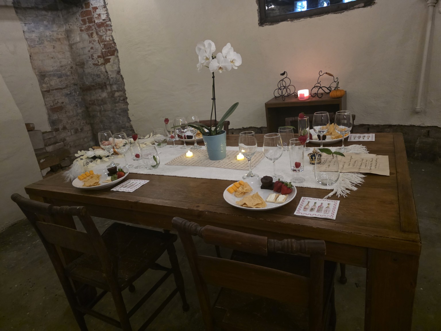 A tasting table set in The Cellars with small plates and wine glasses